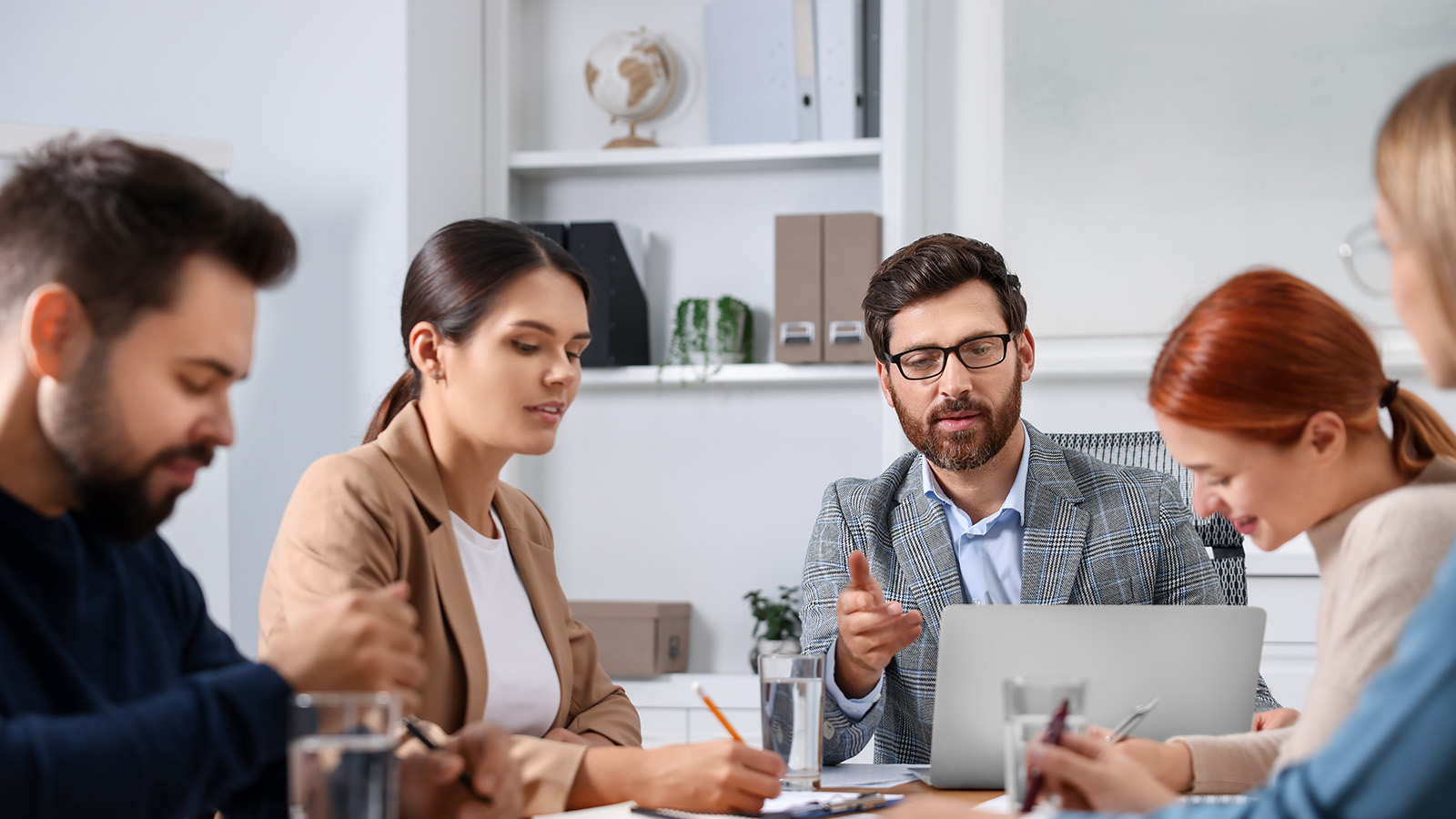 Three women and two men in an office meeting